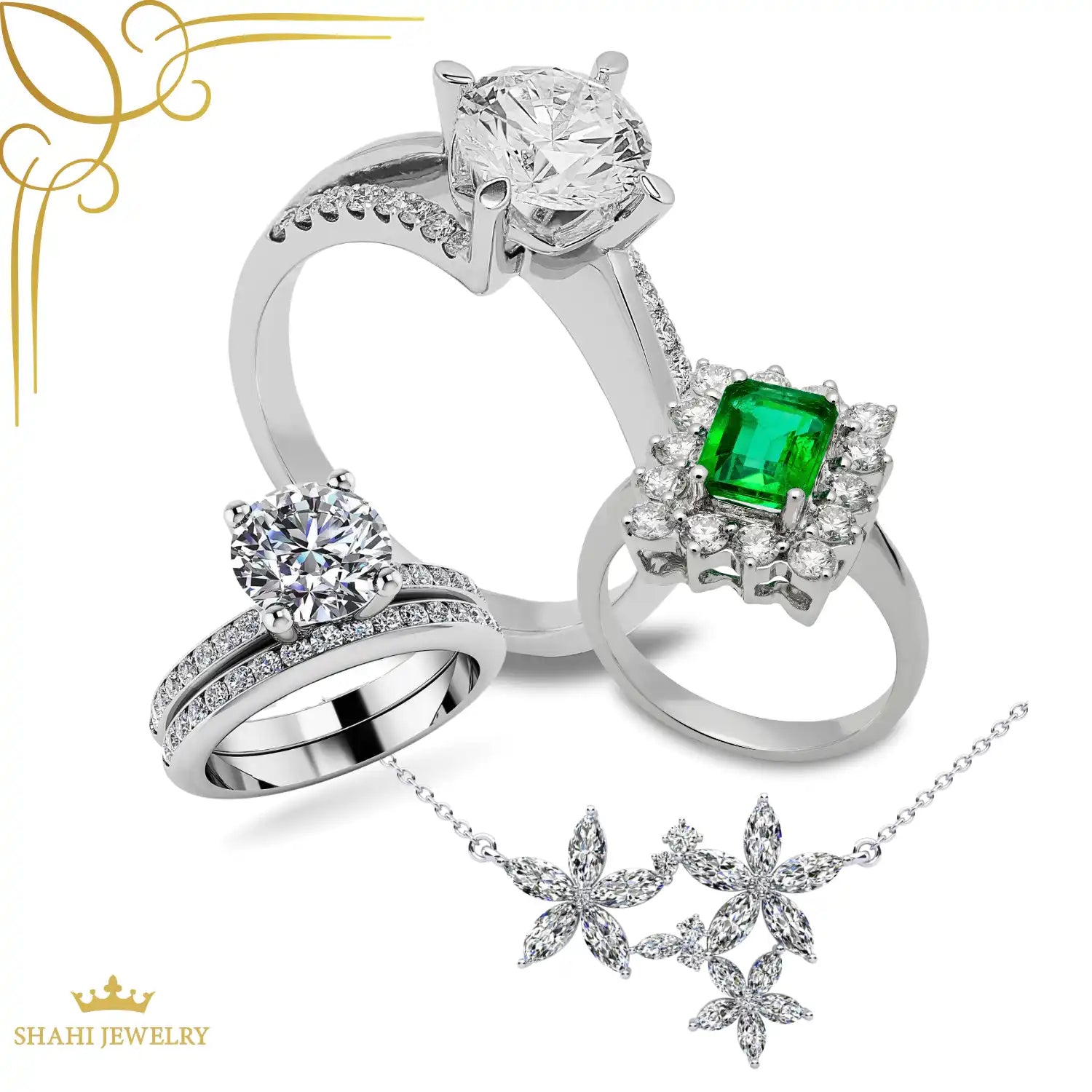 An assortment of diamond and emerald jewelry, including rings and a floral necklace.